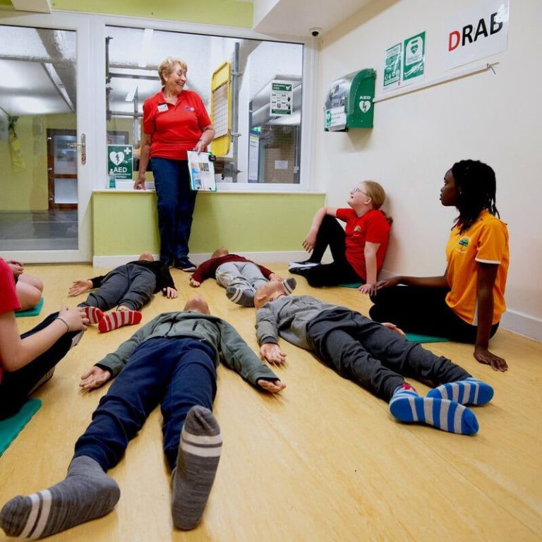 A Life Skills volunteer teaches some local children first aid.