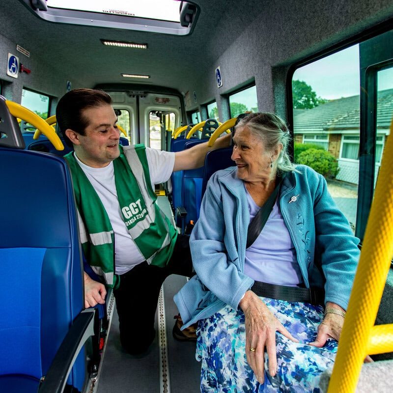 A Green Community Transport volunteer driver talking to a passenger in a minibus.